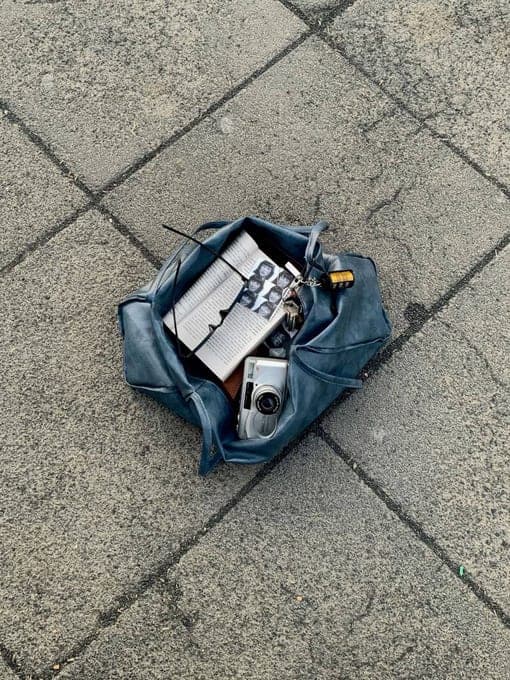 Sac en jean ouvert posé sur un sol en pierre
