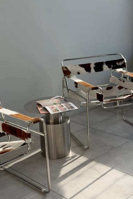 Fauteuil et table basse en métal chargée de magazines, en pleine lumière